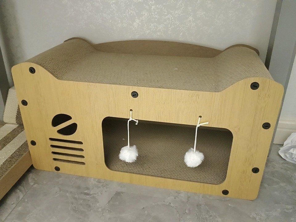 Wooden cat house with two hanging pom-pom toys